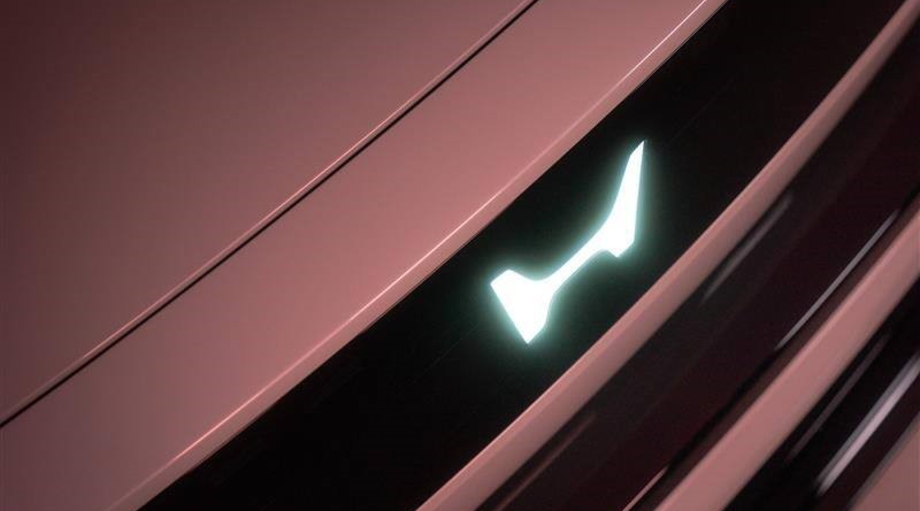 Close-up of a Honda vehicle's front end, showing a sleek pink-tinted body panel and a distinctive illuminated H-shaped headlight design against a dark background.